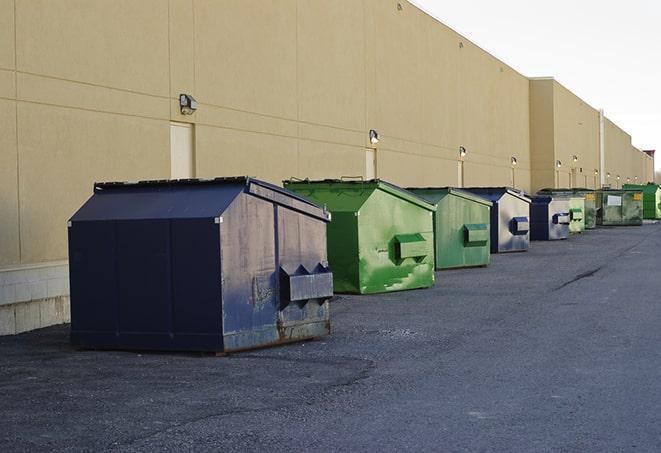 a construction worker moves construction materials near a dumpster in Ellendale, MN